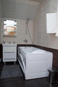 a bathroom with a white tub and a sink at Meridian Hotel in Chekhov