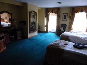 a hotel room with a bed and a television at Corbett Court in Fermoy