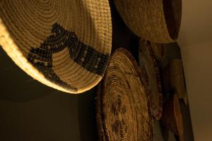 a group of straw hats hanging on a wall at S'accabbadora Guest House in Alghero
