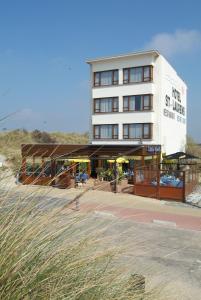 a hotel building with a patio with umbrellas at Sint-Laureins in Westende