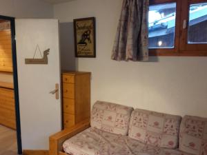 a living room with a couch and a window at Le Thabor in Valfréjus