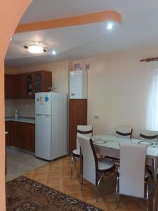 a kitchen with a table and a white refrigerator at Olimpia Apartments in Alba Iulia