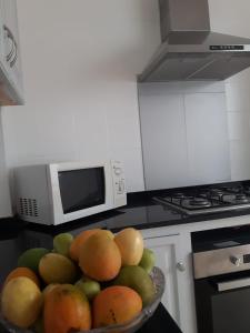 a bowl of fruit in a kitchen with a microwave at Vivienda Vacacional La Aldea de San Nicolas in La Aldea de San Nicolas +25 photos