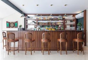 a bar with six chairs in a room at Villa do Vale Boutique Hotel in Blumenau