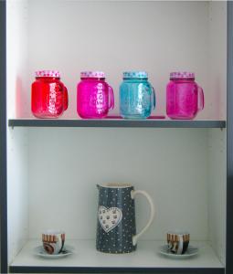 a row of colorful jars on a shelf with cups at Boardinghouse Paderborn in Paderborn