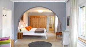 Un dormitorio con una cama blanca y un arco en Gülitzer Landhaus en Gülitz