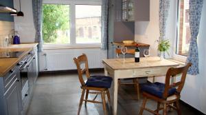 una cocina con mesa con 2 sillas y una botella de vino en Gülitzer Landhaus en Gülitz