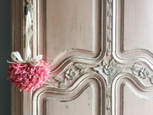 Uma porta com um ramo de flores cor-de-rosa. em Le Duplex de Lapparan em Saint-Drézéry