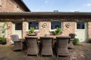 Une table et des chaises en bois sont disponibles sur la terrasse. dans l'établissement B&B ut Good, à Bemelen