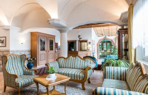 sala de estar con 2 sillas y mesa en Sporthotel Exclusive, en San Vigilio Di Marebbe