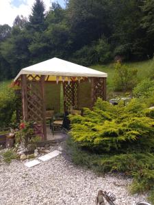 a wooden gazebo with a table and chairs in a garden at Il Ciliegio in Imer