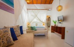 a living room with a bed and a couch at Rio Da Barra Villa Hotel in Trancoso