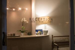 a room with a reception sign and flowers on a table at Al Rustico in Nago-Torbole