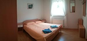 a bedroom with a bed with two blue towels on it at Waldeck Apartment 1 in Kampor