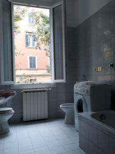 ein Bad mit einem WC-Waschbecken und einem Fenster in der Unterkunft Cirenaica Apartments in Bologna