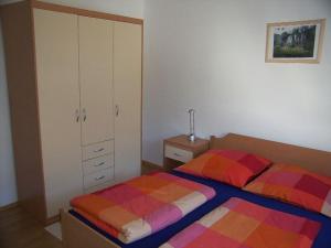a bedroom with two twin beds and a cabinet at Waldeck Apartment 1 in Kampor