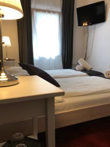 ein Hotelzimmer mit 2 Betten, einem Tisch und einem Fenster in der Unterkunft Donjon B&B e Ristorante in Someo