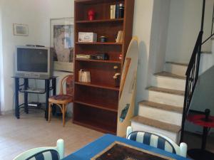 sala de estar con TV y escalera en Cala d'Ambra e Ogliastra en San Teodoro