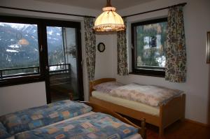 a bedroom with two beds and two windows at Fewo Nr. 15 Haus Konradgut in Sankt Lorenzen ob Murau