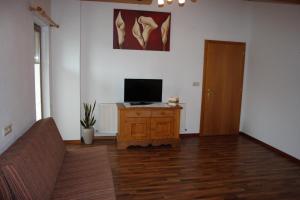 uma sala de estar com televisão num armário de madeira em Appartement Anita em Längenfeld