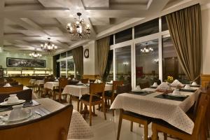 um restaurante com mesas e cadeiras e um lustre em Micheline Hotel Tricot - ao lado da Rua Coberta em Gramado