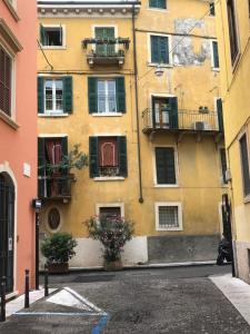 um edifício amarelo com janelas e varandas numa rua em Dimora Tito Speri near Arena em Verona