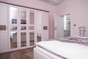 ein weißes Schlafzimmer mit einem Bett und einem Schrank in der Unterkunft Ferienwohnung am Freizeitpark Bärenloch in Solingen