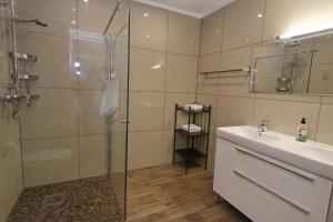 a bathroom with a glass shower and a sink at Justhostel in Gdańsk