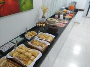 um buffet com muitos tipos diferentes de pastelaria e bolos em Master Hotel em Balneário Camboriú
