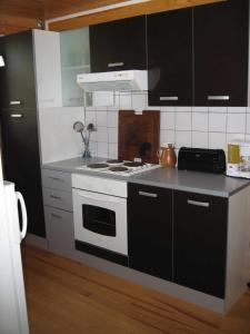 uma cozinha com um fogão branco e armários pretos em Domaine de la Pinsonnière em La Livinière