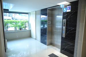 an elevator in an office building with a window at Great Family Hotel in Taipei