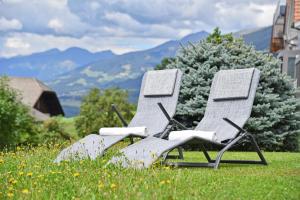 zwei Stühle im Gras auf einem Feld in der Unterkunft Fuchshof in Percha