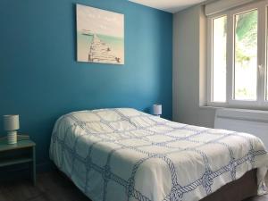 une chambre bleue avec un lit et une fenêtre dans l'établissement La Plage d'Or, à Vierville-sur-Mer
