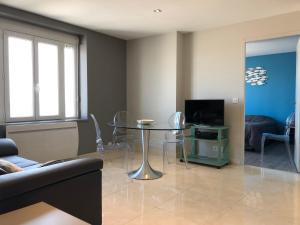 un salon avec une table et une télévision dans l'établissement La Plage d'Or, à Vierville-sur-Mer 5 autres photos