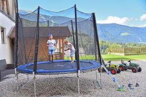 two children are playing on a trampoline at Fuchshof in Perca