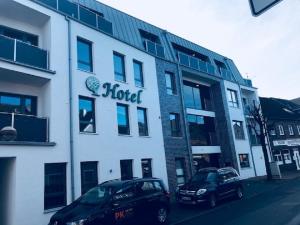 un hotel con dos coches estacionados frente a él en Hotel an der Burgschänke en Alpen