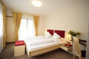 sypialnia z dużym łóżkiem w pokoju w obiekcie Hotel Verena w mieście Lana