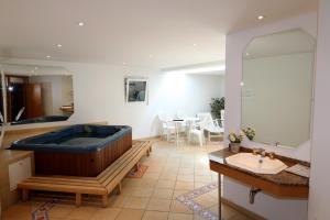 a large bathroom with a tub and a sink at Cornelia in Saas-Fee