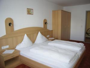 um quarto com uma cama grande e lençóis brancos em Haus Bergkristall em Obergurgl