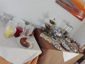 einen Tisch mit Teller mit Lebensmitteln und Gläsern Orangensaft in der Unterkunft Amaryllis in San Vito lo Capo