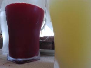 ein Glas rote Flüssigkeit neben einem Drink in der Unterkunft Amaryllis in San Vito lo Capo