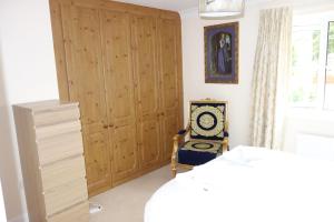 1 dormitorio con un gran armario de madera y una silla en 'Heart Of Avalon' 500 metres to town centre, en Glastonbury