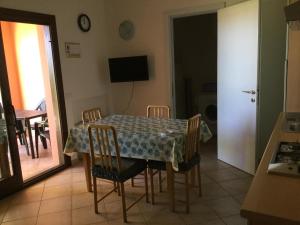 une salle à manger avec une table, des chaises et une télévision dans l'établissement Borgo Di Murta Maria House, à Murta Maria