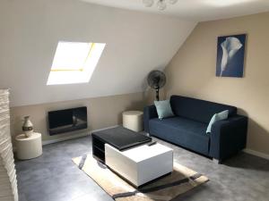 sala de estar con sofá azul y TV en Les Charmantes, en Cernay