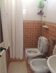 a bathroom with a toilet and a sink at Guesthouse Hygge in Tirana