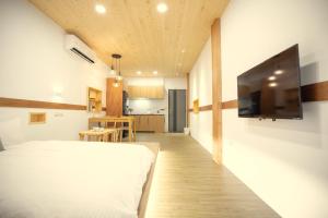 um quarto com uma cama e uma televisão na parede em Lost Circle Homestay em Tainan