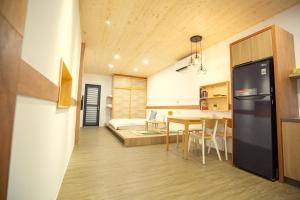 a kitchen and dining room with a refrigerator and a table at Lost Circle Homestay in Tainan +47 photos