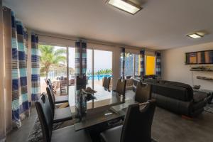 a living room with a glass table and chairs at Zeza´s house in Calheta