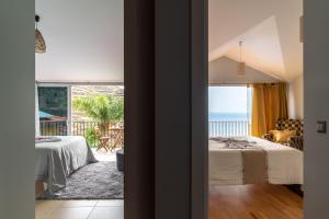 a bedroom with a bed and a view of the ocean at Zeza´s house in Calheta +29 photos