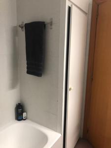 La salle de bains est pourvue d'une baignoire et d'une serviette noire. dans l'établissement Modern Homely Beach Side Apartment, à Vinaròs